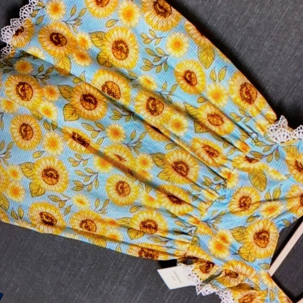 Featuring a delightful sunflower print blouse
